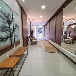 Hall de corredor com revestimento de madeira nas paredes.