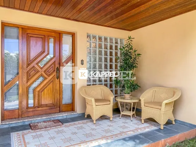 Sala com duas poltronas de vime e piso de cerâmica.
