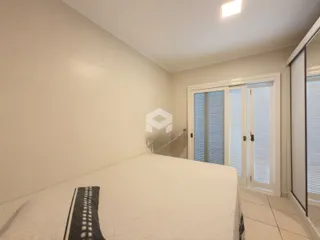Quarto com cama de casal e paredes brancas.
