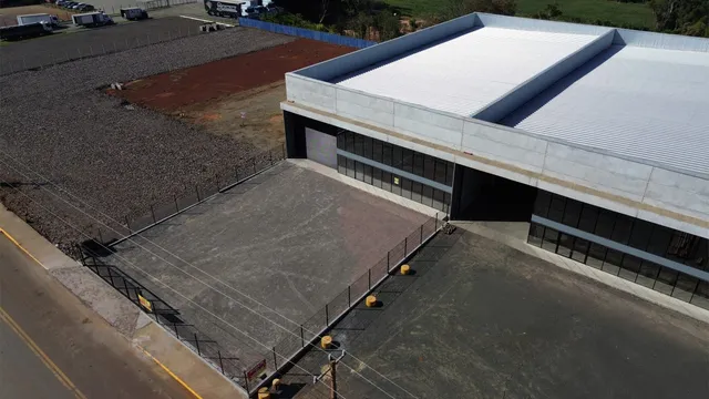 Vista externa de um edifício comercial com área de estacionamento adjacente em Lajeado.
