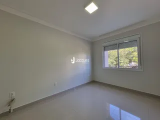 Ambiente interno de uma sala com piso de porcelanato e janela.
