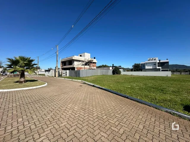 Vista externa de uma propriedade em Lajeado, Brasil, com área gramada e edificações ao fundo.