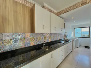 Foto de uma cozinha moderna com armários brancos e revestimento de azulejos coloridos.