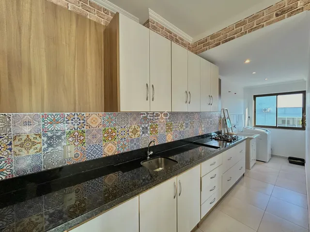 Foto de uma cozinha moderna com armários brancos e revestimento de azulejos coloridos.