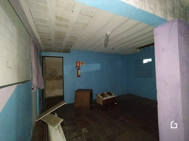 Imagem interna de uma sala com paredes azuis e teto branco.