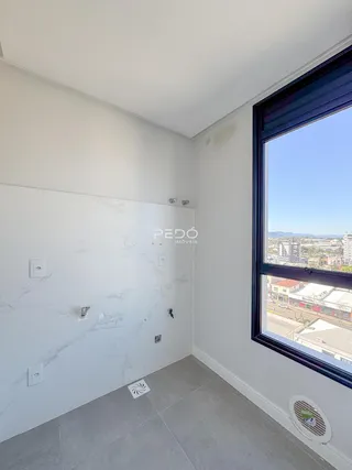 Parede interna com revestimento de mármore e janela de vista para a cidade.