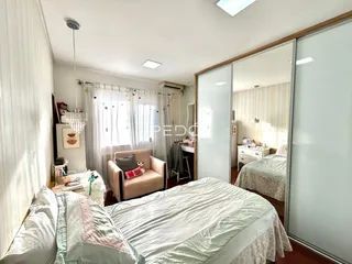 Quarto com cama e sofá em ambiente interno.