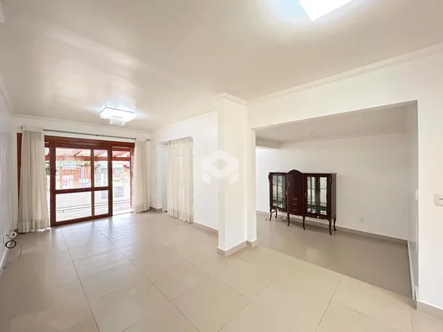 Ambiente interno amplo com piso de cerâmica claro e portas de vidro que dão acesso ao exterior.