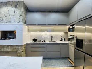 Cozinha moderna com armários cinzas e bancadas brancas.