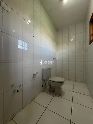 Foto de um banheiro com revestimento cerâmico branco.