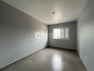 Vista interna de um corredor com paredes cinzas e piso claro.