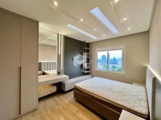 Quarto com vista para a cidade e piso de madeira clara.