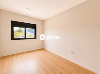 Foto de um ambiente interno com piso de madeira e janela.