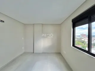 Ambiente interno de uma sala com piso de cerâmica e janela para a vista da cidade.