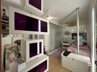 Quarto com decoração moderna e estantes embutidas em um imóvel no Brasil.