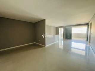 Ambiente interno de uma sala ampla com piso claro.
