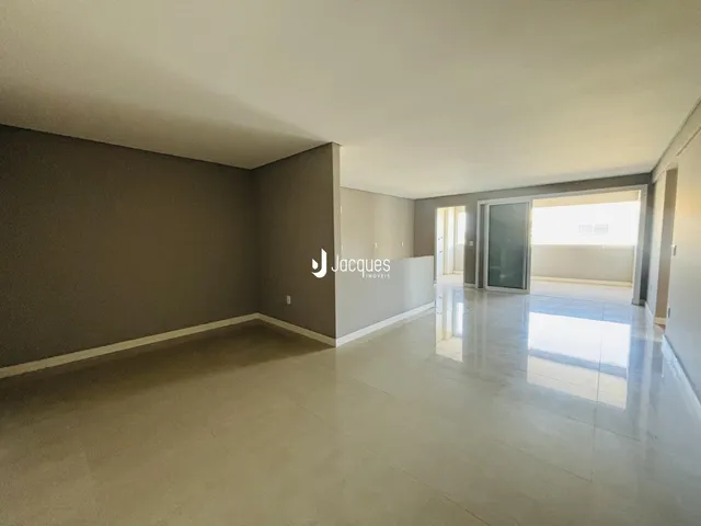 Ambiente interno de uma sala ampla com piso claro.