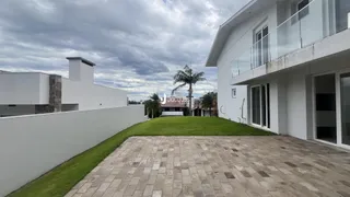 Fachada de uma residência moderna com jardim e área pavimentada.