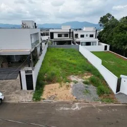 Área externa gramada com muros brancos em uma propriedade em Lajeado.