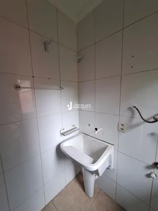 Foto de um banheiro com revestimento cerâmico branco.
