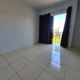 Foto de um cômodo interno com piso de cerâmica e cortinas escuras.