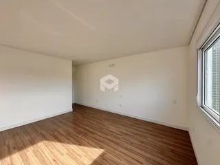 Ambiente interno com piso de madeira clara e paredes brancas.