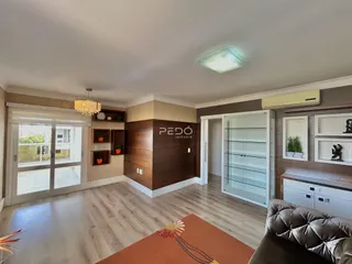 Interior de uma sala com piso de madeira e portas de vidro deslizantes.
