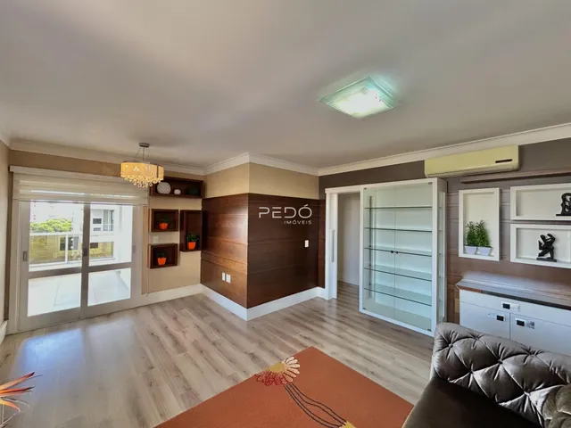 Interior de uma sala com piso de madeira e portas de vidro deslizantes.