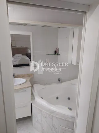 Foto de um banheiro interno com banheira e revestimento claro.