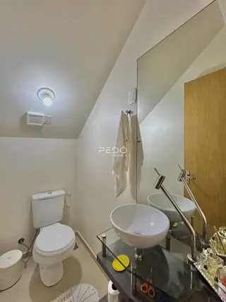 Foto de um banheiro moderno com pias e vaso sanitário brancos.