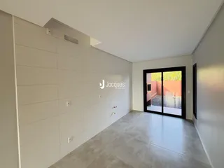 Ambiente interno de uma residência com paredes brancas e piso claro.