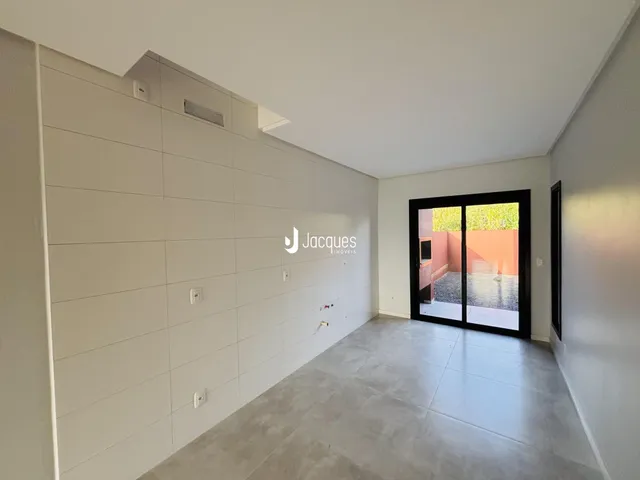 Ambiente interno de uma residência com paredes brancas e piso claro.