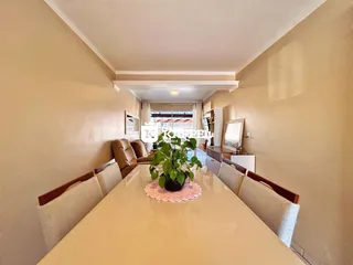 Vista de uma mesa de jantar com assentos em um ambiente interno claro.