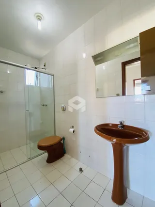 Banheiro com piso de cerâmica e box de vidro transparente.