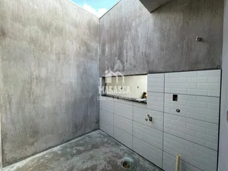 Parede interna com textura áspera e piso de concreto em um imóvel.