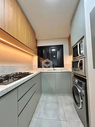 Foto de uma cozinha moderna com armários de madeira e bancadas claras.