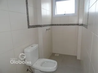 Interior de um banheiro com revestimento cerâmico nas paredes.