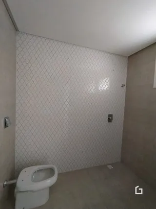 Foto de um banheiro interno com paredes brancas e azulejos.