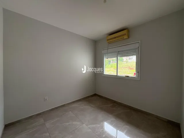 Ambiente interno de uma sala com paredes brancas e piso claro.