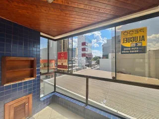 Vista de uma sala com paredes azuis e teto de madeira olhando para um prédio urbano.
