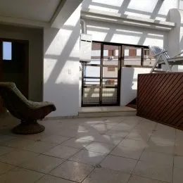 Foto interna de uma sala com piso de cerâmica e iluminação natural.
