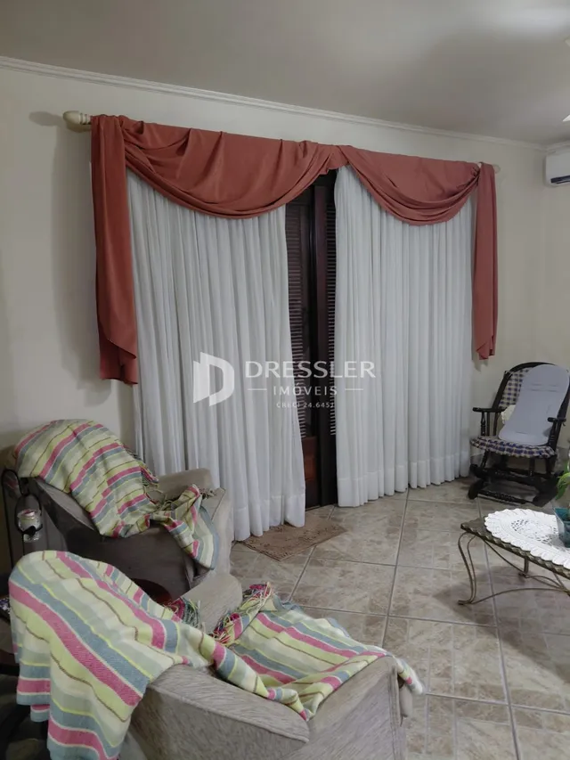 Ambiente interno com cortinas e móveis em uma sala.