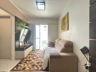 Sala de estar com sofá e televisão em um imóvel no Brasil.