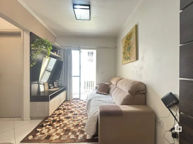 Sala de estar com sofá e televisão em um imóvel no Brasil.