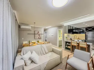 Sala de estar com sofá e decoração clara em um apartamento no Brasil.