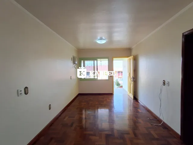 Hall de entrada com piso de madeira e paredes claras.