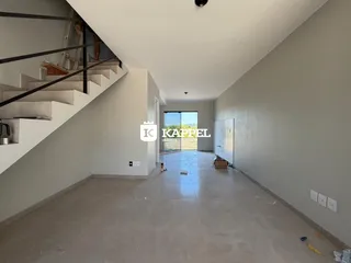 Hall de entrada com escadaria e área aberta em construção.