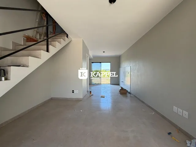 Hall de entrada com escadaria e área aberta em construção.