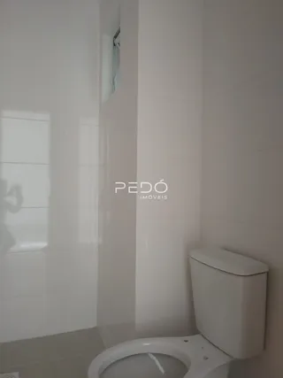 Foto de um banheiro com paredes brancas e azulejos.