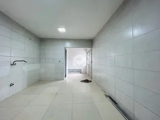 Corredor interno de uma residência com paredes brancas e piso claro.